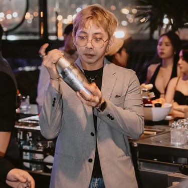 Zion Sky Lounge & Dining Ho Chi Minh Vietnam Saigon Bartender wearing a black shirt and gray sports coat shake a mixer at bar