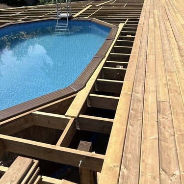 Above-ground pool under renovation with a wooden deck being built and a metal ladder beside blue water.