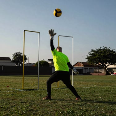 A quadball keeper guarding three tall hoops on a grassy pitch in Lima, late-afternoon dramatic sun.