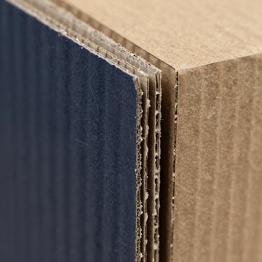 Macro shot of a 3-ply corrugated cardboard flute profile, sharp technical lighting, raw kraft paper texture