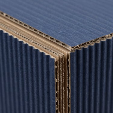 Close-up of a 5-ply double-wall corrugated cardboard cross-section, industrial B2B photography, deep navy tones