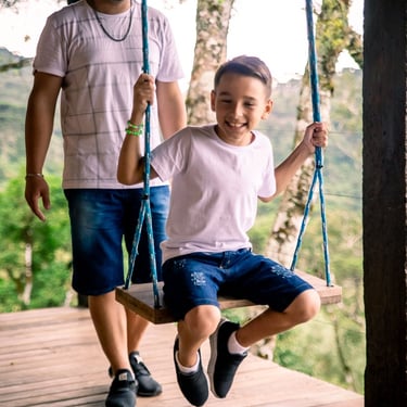 Pai empurra filho em balanço na varanda da cabana Wolken Haus Urubici