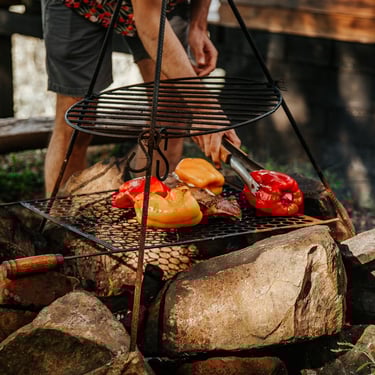 Hospede faz churrasco na fogo de chão da cabana rústica de madeira em Urubici Serra Catarinense