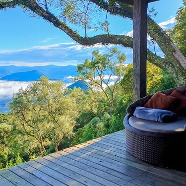 Poltrona gigante na varanda da cabana de montanha Wolken Haus Urubici com vista para as montanhas do morro da igreja