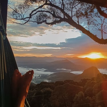 Vista incrível pessoa de férias descansando na rede com nascer do sol e mar de nuvens ao fundo