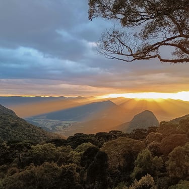 Raios de sol passando pelas nuvens e jogando por todo o vale com vista incrível das montanhas na cabana Urubici Wolken Haus