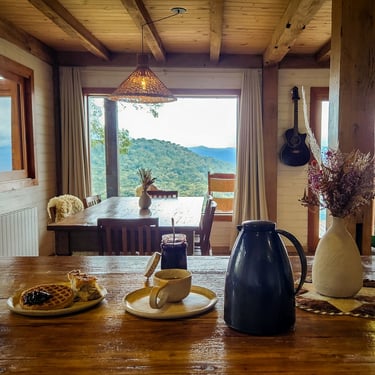 Mesa de café da manhã do living integrado na casa de montanha com vista das montanhas mesa grande radiador de aquecimento