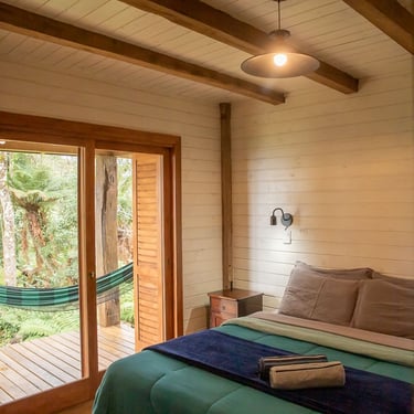 Quarto com acesso a varanda com rede e vista para floresta cama queen e estilo rustico em Urubici Morro da Igreja