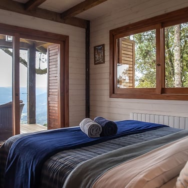 Suite cabana urubici com vista panoramica do mar de nuvens e janela para bosque de natureza com cama queen size