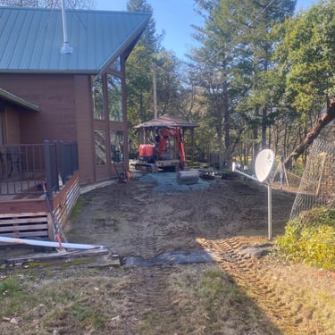 Excavator to right of house, spreading gravel