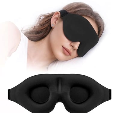 Woman wearing a black 3D contoured sleep mask for total light blocking and better sleep.