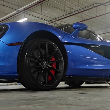 Proceso de aplicación de recubrimiento cerámico en auto deportivo con técnica avanzada de detallado automotriz.