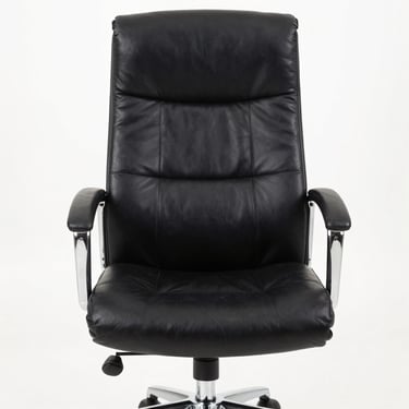 Studio straight-on shot of a high-back black leather executive chair with wide padded headrest, chrome armrests, polished chrome star base, against a clean white background, bright even lighting