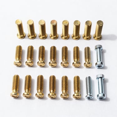 Straight-on catalog shot of organized solid brass bolts and steel hand tools arranged neatly on a crisp white background.