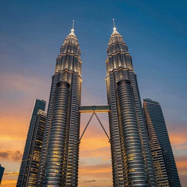 The futuristic Petronas Twin Towers in Kuala Lumpur reflecting twilight blue and orange sky