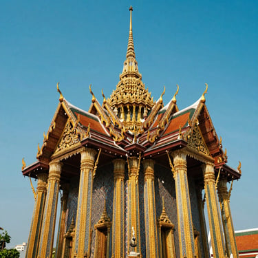 An ornate golden temple in Bangkok glittering under clear blue sky, detailed carvings