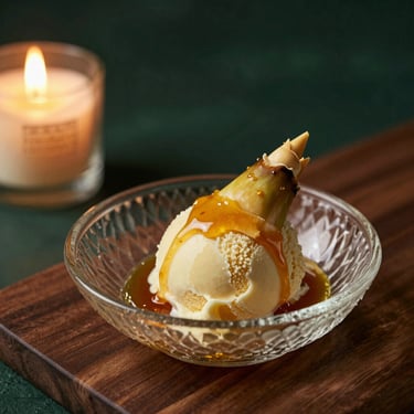 Artful dessert of bamboo shoot ice cream with caramelized local honey, textured glass dish, shallow depth of field, warm candlelight, 50mm