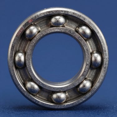 Macro shot of a pristine steel ball bearing, metallic texture, clean studio lighting, deep blue background