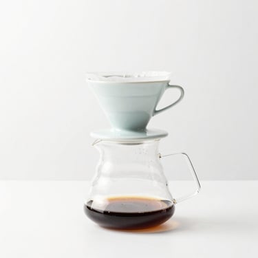 Minimalist manual brew coffee setup, V60 dripper, glass server, clean white background, soft studio light