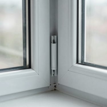 Macro photograph of a seamless uPVC window corner joint, clean grey profile, multi-point locking hardware visible, bright architectural light, desaturated cool tones