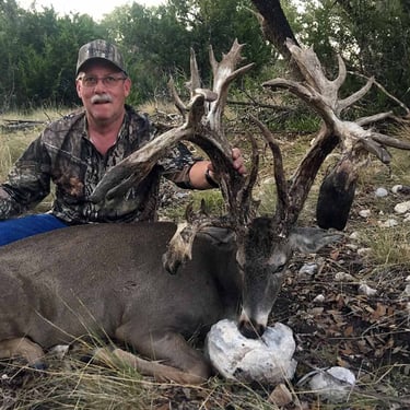 Proud hunter with a giant non-typical whitetail buck in the Texas Hill Country.