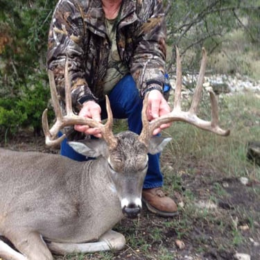 Hunter with a massive wide-rack whitetail buck during a Texas Hill Country guided hunt.