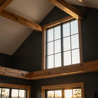 Interior detail of a newly constructed modern farmhouse, soft natural window light illuminating high ceilings and warm wooden beams, 35mm.