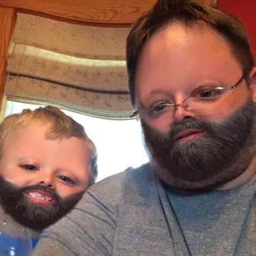Funny face swap photo of a man and a young child with edited beards for a humorous effect.