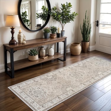 Vintage persian runner rug on hardwood floors in a modern entryway with console table and plants.