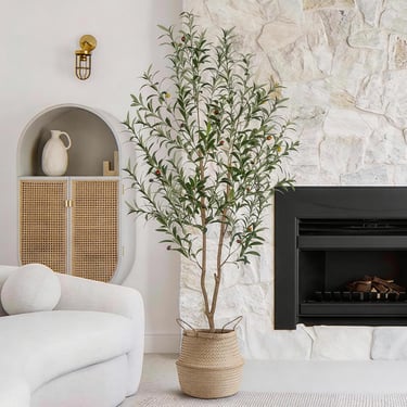 6FT artificial olive tree styled in a cozy living room beside a fireplace