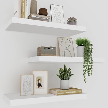 Minimalist white floating shelves featuring modern home decor, potted plants, and framed art.