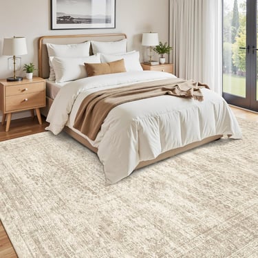 Distressed beige and cream area rug in a modern bedroom with a white duvet and wooden nightstands.
