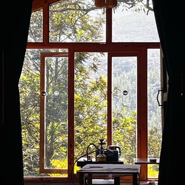 A beautiful view of mountains through the windows of a wooden cottage in Chikmagalur