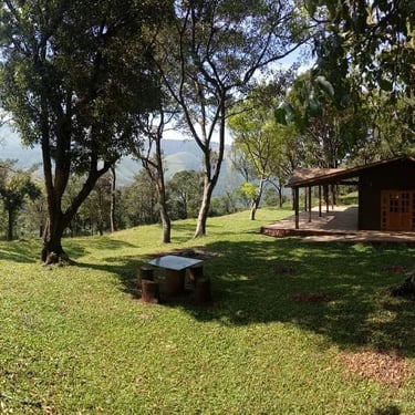 A cozy wooden cottage built on top of a mountain with a beautiful view of the mountains in Chikmagalur