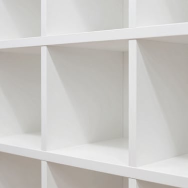 Close-up of a brightly lit toy display shelf with clean geometric white partitions, high-key studio lighting, sharp focus