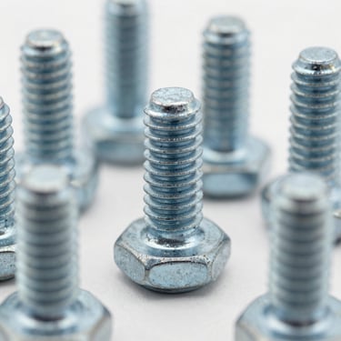 Macro shot of high-tensile steel industrial bolts and threaded screws, sharp metallic textures