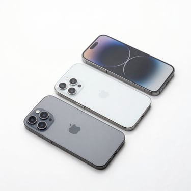 Minimalist flat-lay of three modern iPhones arranged diagonally on a bright white surface, soft studio lighting, clean glass reflections
