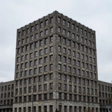 Symmetrische Architekturaufnahme eines brutalistischen Betongebäudes in Berlin bei bewölktem Himmel, extrem minimalistisch.