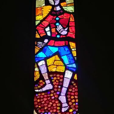 stained glass character crushing grapes with feet