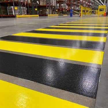 Marcaje tactile și linii de siguranță pentru delimitarea zonelor de pericol în hale industriale.