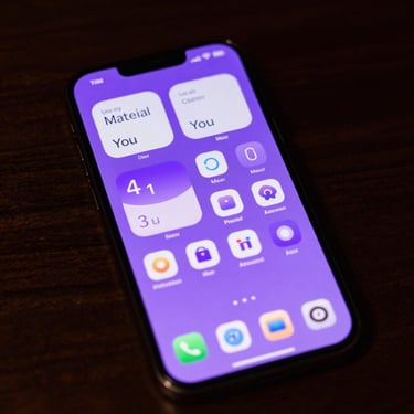 Macro shot of a modern Android phone screen displaying a minimalist custom launcher with violet Material You accents, soft ambient screen-glow on a dark wood desk.