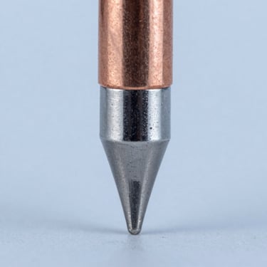 Extreme macro cross-section of a soldering tip showing the copper core, iron plating layer, and chrome stop-off, studio technical lighting, high contrast, 1:1 square