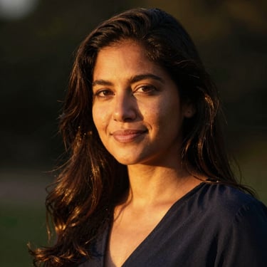 Serene portrait of a Latina woman with a soft smile, warm golden-hour lighting, dark background.