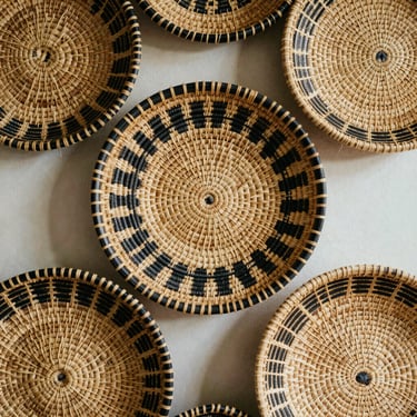 Woven seagrass circular wall basket set, intricate black and natural patterns