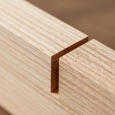 Macro detail of a hand-planed mortise and tenon joint in white oak, crisp natural light showing wood grain.