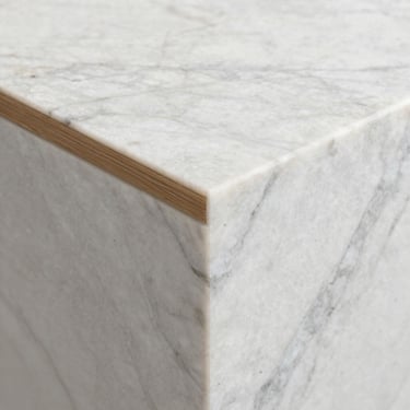 Tight geometric detail crop of premium white marble texture meeting a raw oak timber joint, soft diffused daylight highlighting the material grain.