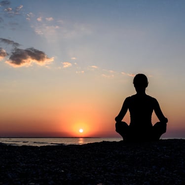 Woman meditating at sunrise in Miches Dominican Republic during a peaceful beach retreat