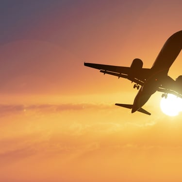 Airplane flying into a golden sunset sky en route to the Dominican Republic