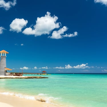 Scenic beach with turquoise water and striped lighthouse in Bayahibe, Dominican Republic