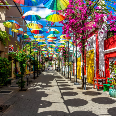 Colorful umbrella street with vibrant walls and flowers in Puerto Plata, Dominican Republic